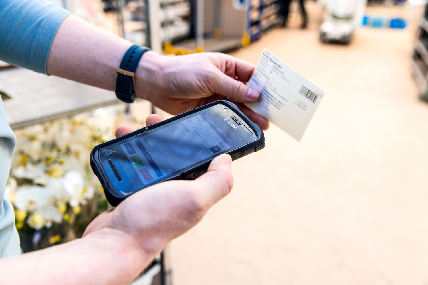 Employee scanning a packing slip with SDF software for order processing and traceability in floriculture